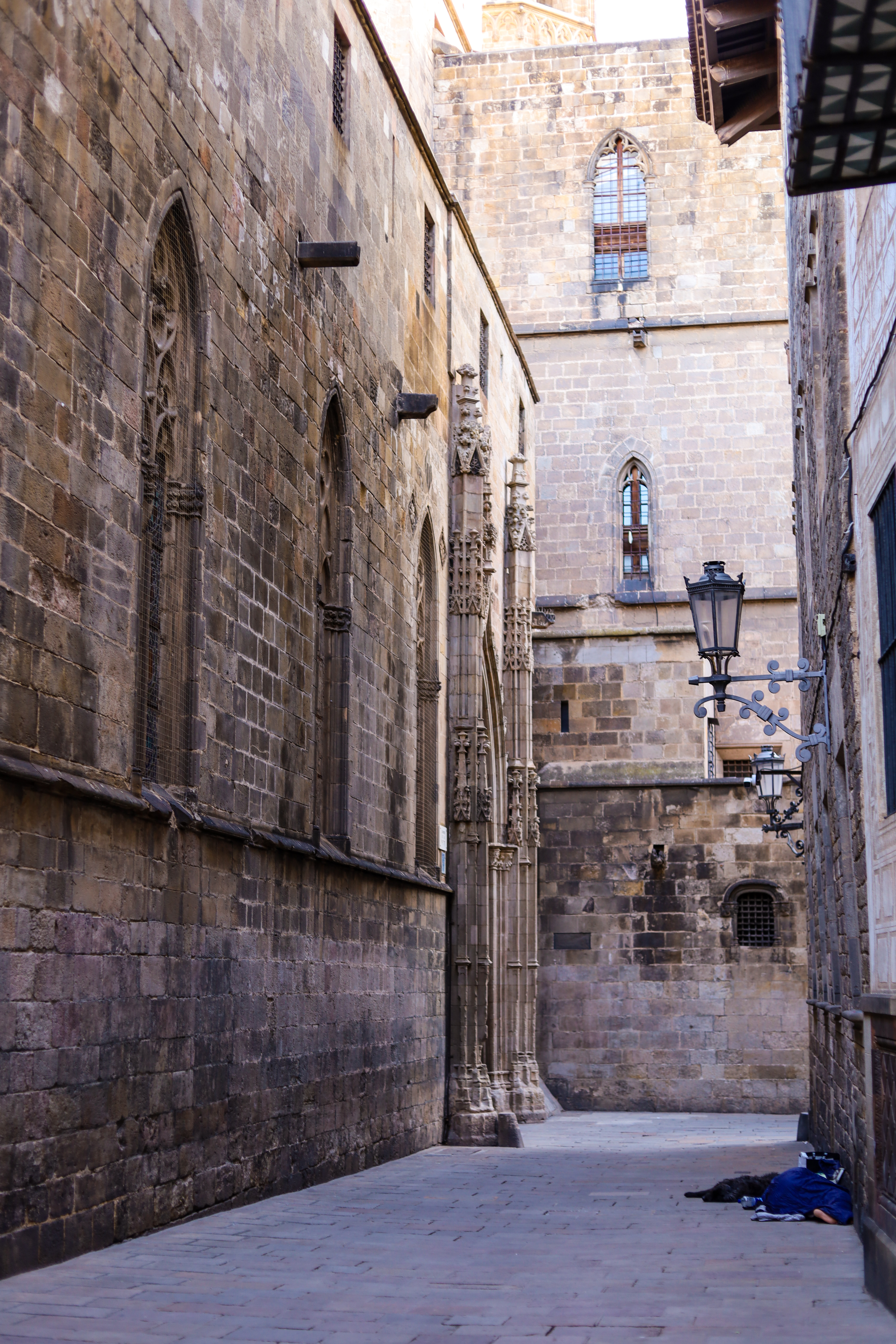 Gothic stone columns and a lantern in a quiet alley near the Cathedral