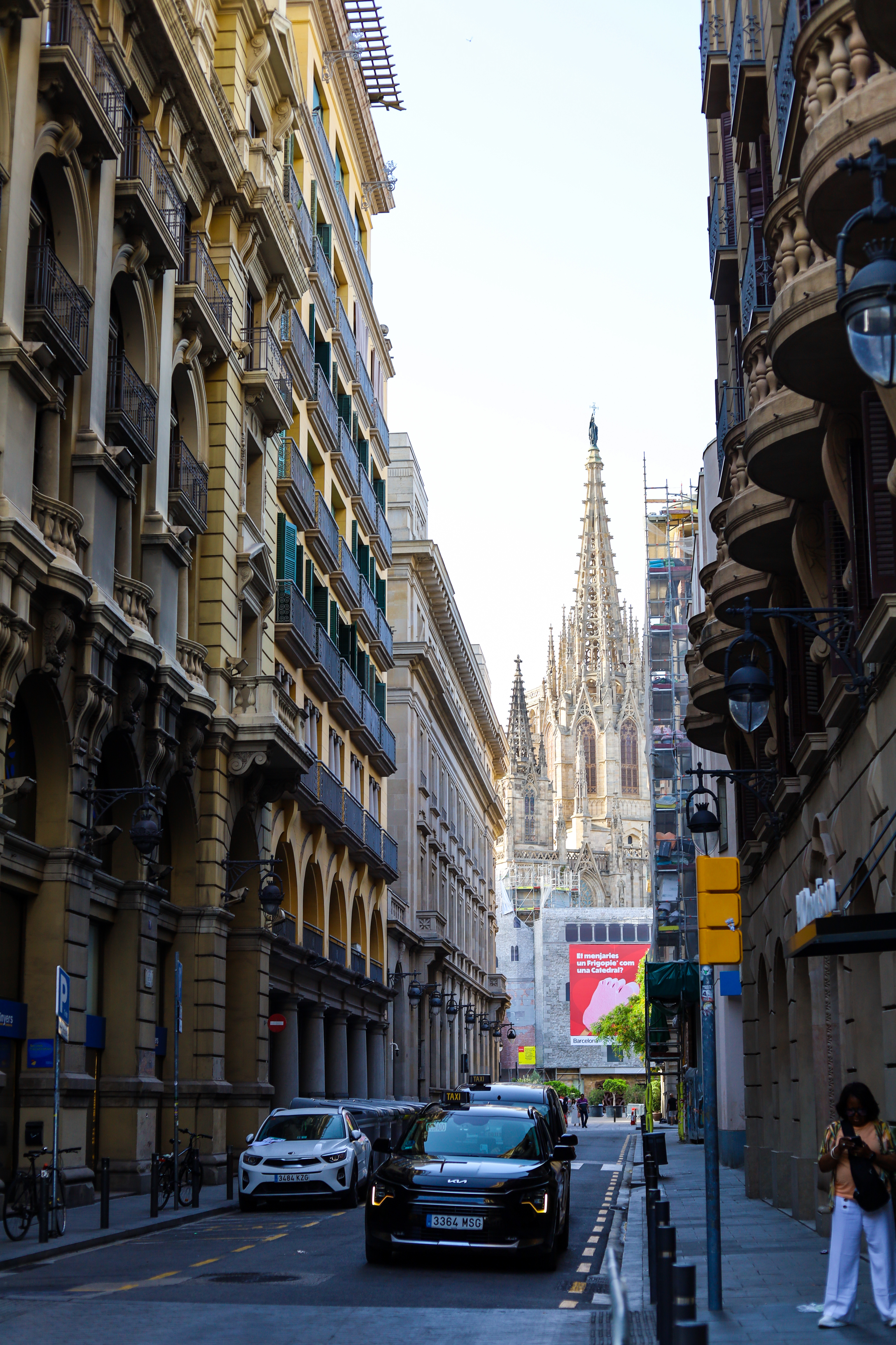 Barcelona street framing the cathedral spire at the end of the corridor