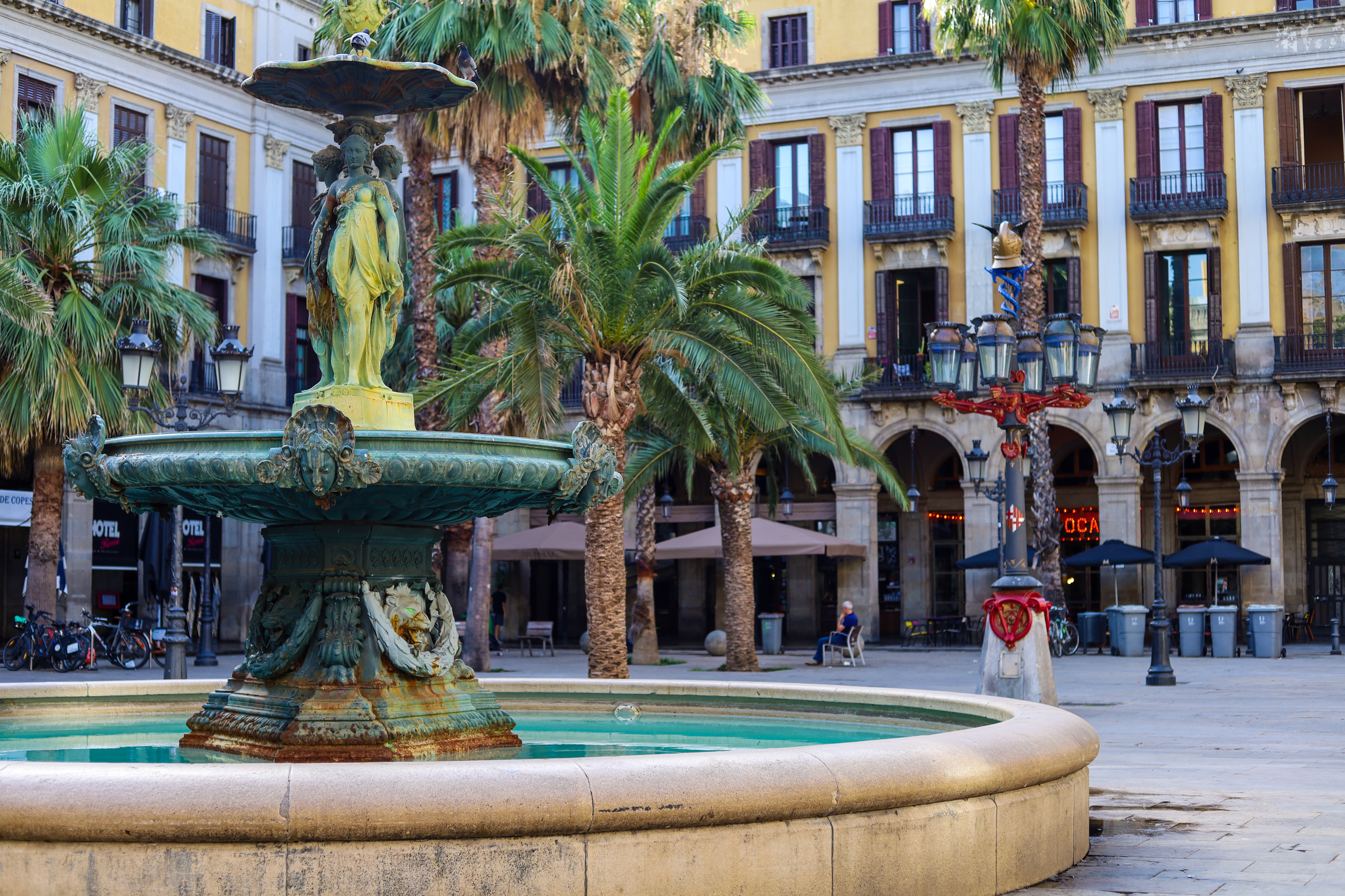 Plaça Reial fountain and palm trees surrounded by yellow neoclassical buildings